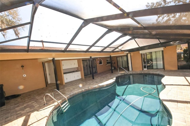 outdoor pool with glass enclosure and a patio