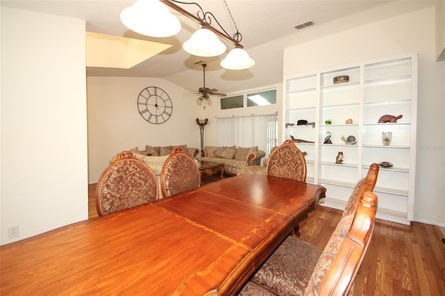 dining room with lofted ceiling, visible vents, ceiling fan, and wood finished floors