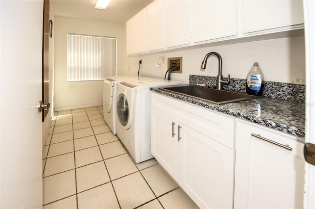 laundry room with cabinet space, baseboards, washer and clothes dryer, a sink, and light tile patterned flooring