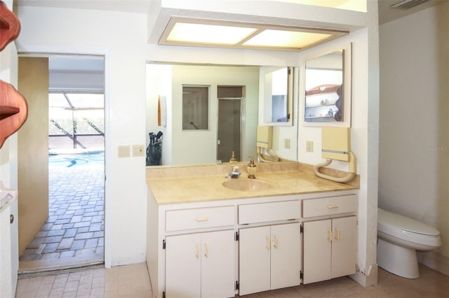 full bathroom with brick floor, vanity, toilet, and a shower with door