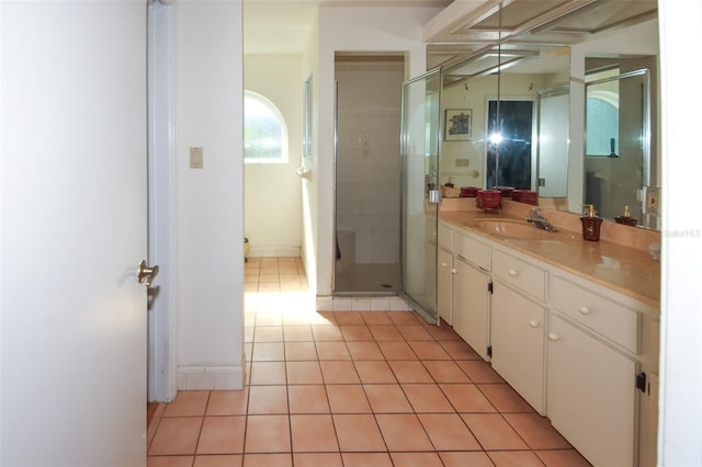 bathroom featuring tile patterned flooring, vanity, and a shower stall