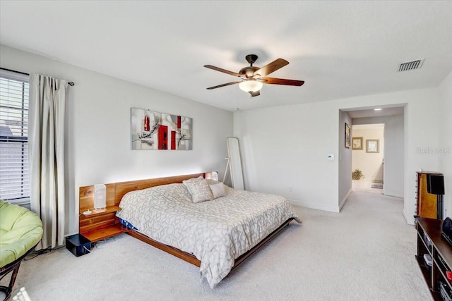 carpeted bedroom featuring ceiling fan, visible vents, and baseboards