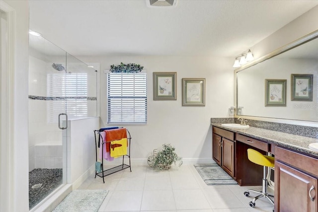 full bath with a sink, baseboards, a shower stall, tile patterned floors, and double vanity