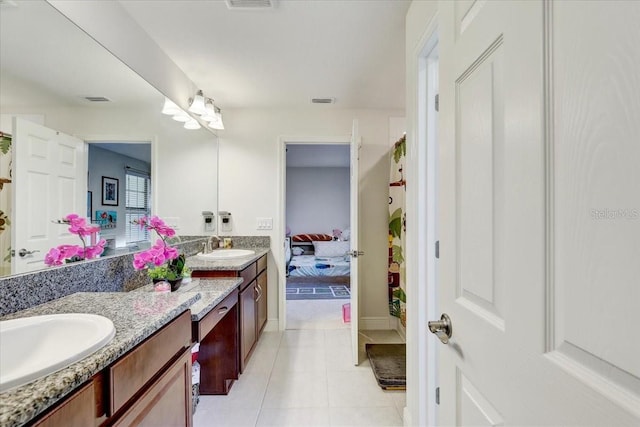 ensuite bathroom featuring tile patterned floors, visible vents, a sink, and double vanity