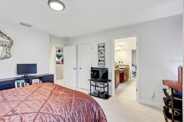 bedroom featuring baseboards, visible vents, ensuite bathroom, and light colored carpet