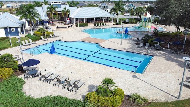 community pool featuring a residential view, fence, and a patio