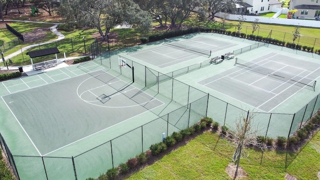 view of sport court featuring community basketball court, a lawn, and fence