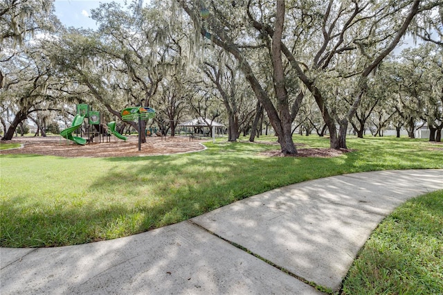 surrounding community with playground community and a lawn