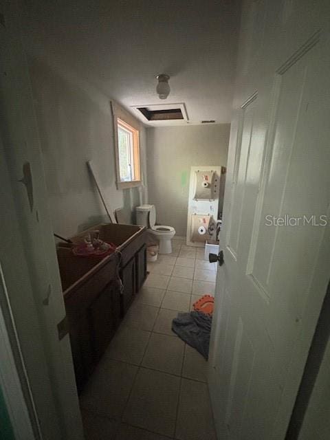 bathroom with toilet, tile patterned flooring, and vanity