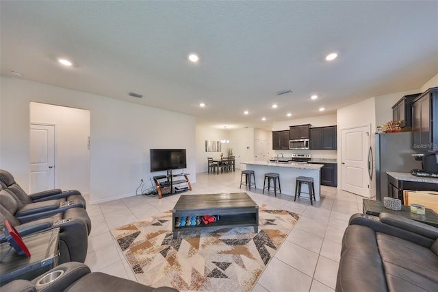 living room with light tile patterned floors, visible vents, and recessed lighting