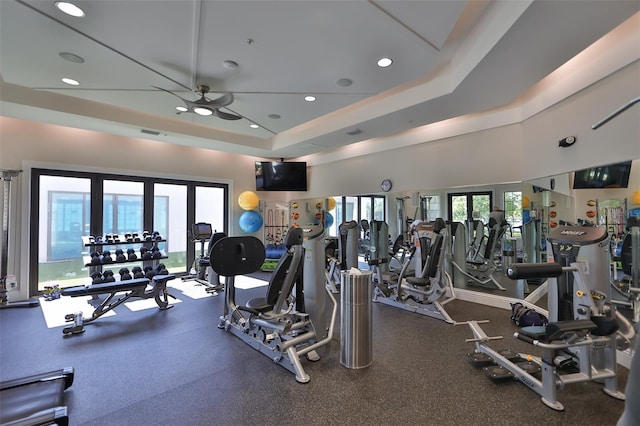 exercise room featuring plenty of natural light, a tray ceiling, ceiling fan, and french doors