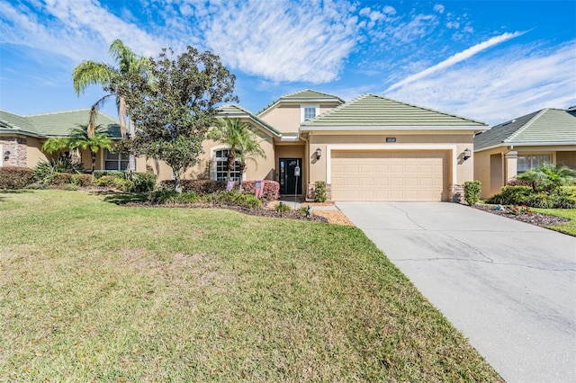 view of front of property with a front yard, stucco siding, concrete driveway, a garage, and a tiled roof