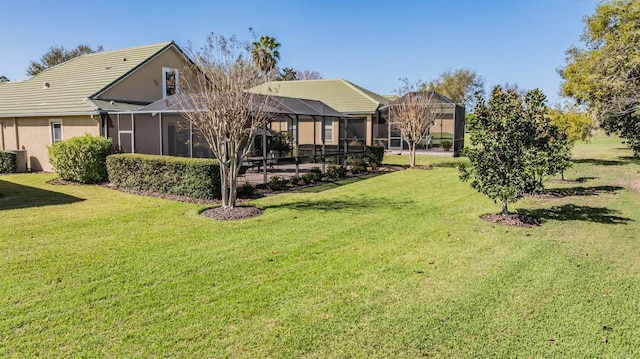 rear view of house with a lanai, central AC unit, a lawn, and stucco siding