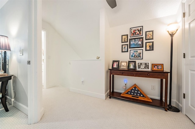 interior space featuring vaulted ceiling, baseboards, and carpet floors