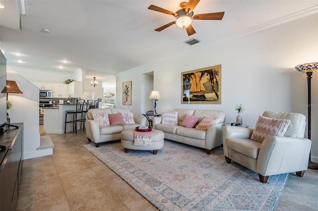 living area featuring light tile patterned floors, visible vents, crown molding, and ceiling fan with notable chandelier