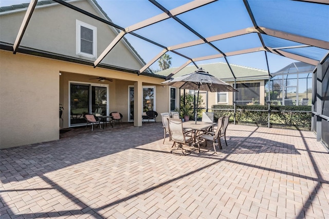 view of patio featuring outdoor dining space, a lanai, and ceiling fan