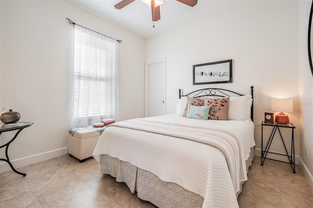 tiled bedroom featuring ceiling fan and baseboards