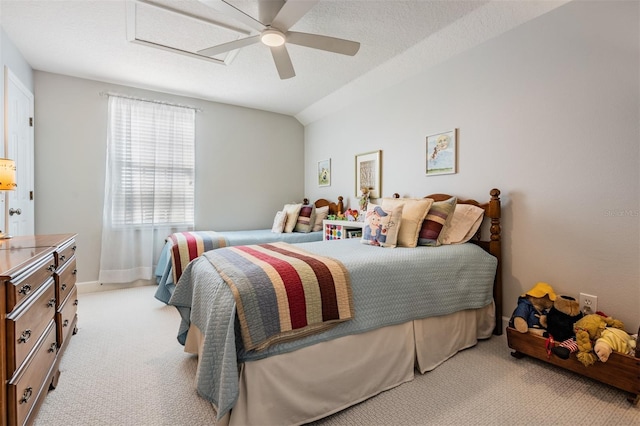 bedroom featuring light carpet, a textured ceiling, attic access, and a ceiling fan