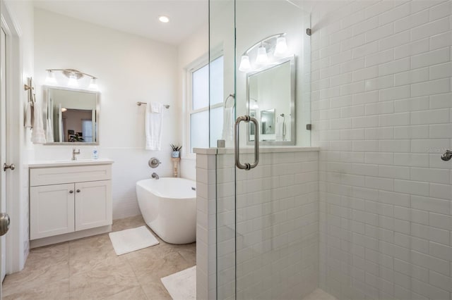 full bathroom with a freestanding tub, a stall shower, tile walls, wainscoting, and vanity