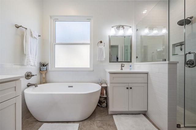 full bath with a soaking tub, vanity, tile walls, and a shower stall