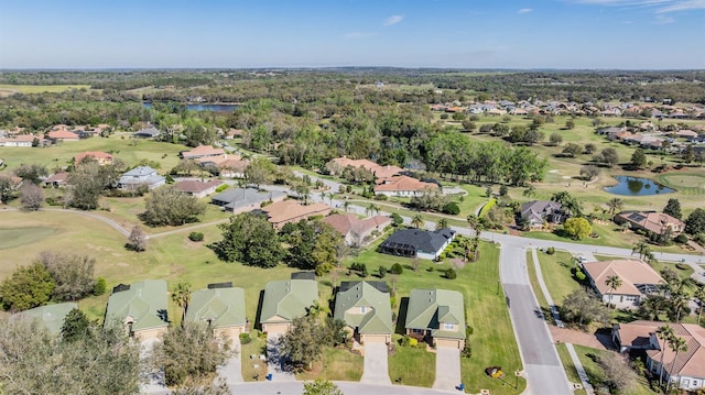 drone / aerial view with a residential view, golf course view, and a water view