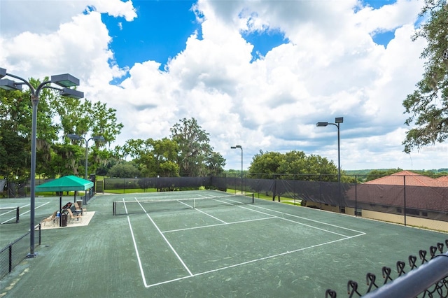 view of tennis court featuring fence