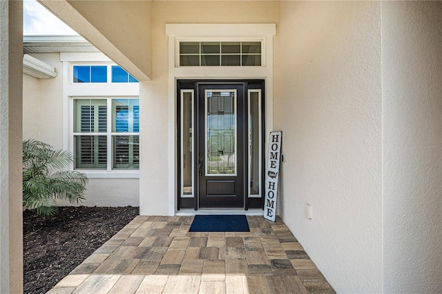 view of exterior entry featuring stucco siding and a wall unit AC