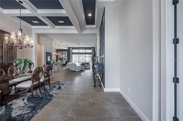 interior space with an inviting chandelier, coffered ceiling, beamed ceiling, ornamental molding, and baseboards