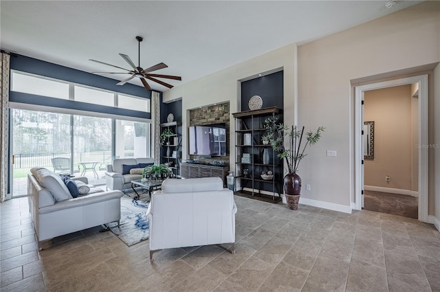 living room featuring baseboards and a ceiling fan