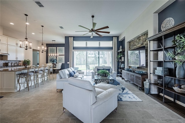 living area featuring recessed lighting, visible vents, and ceiling fan with notable chandelier
