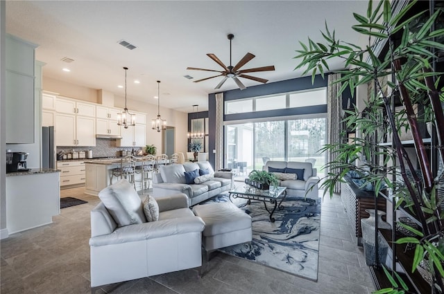 living room with recessed lighting, visible vents, and ceiling fan with notable chandelier
