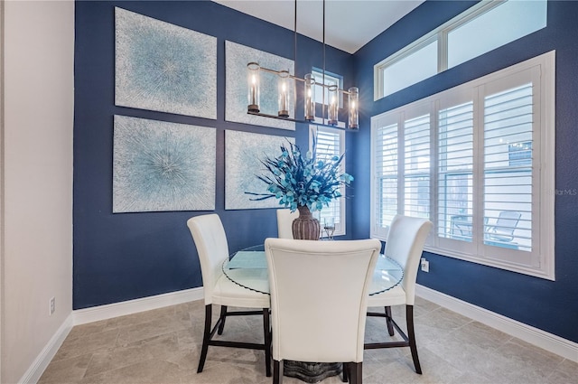 dining space featuring an inviting chandelier, tile patterned floors, and baseboards
