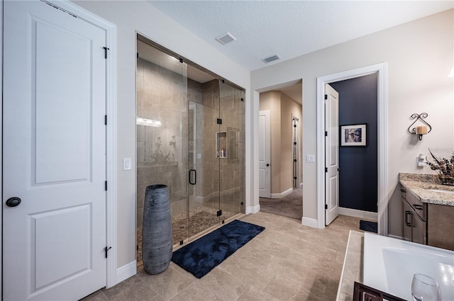 full bathroom featuring visible vents, a shower stall, vanity, and baseboards