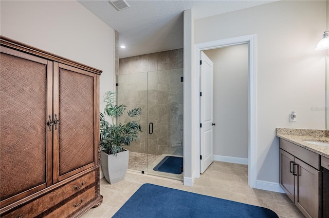 bathroom featuring a stall shower, tile patterned flooring, visible vents, and vanity