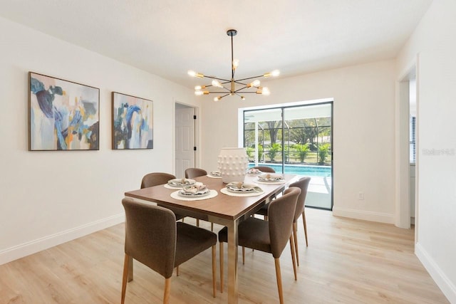 dining area featuring light wood-style flooring, baseboards, and a chandelier