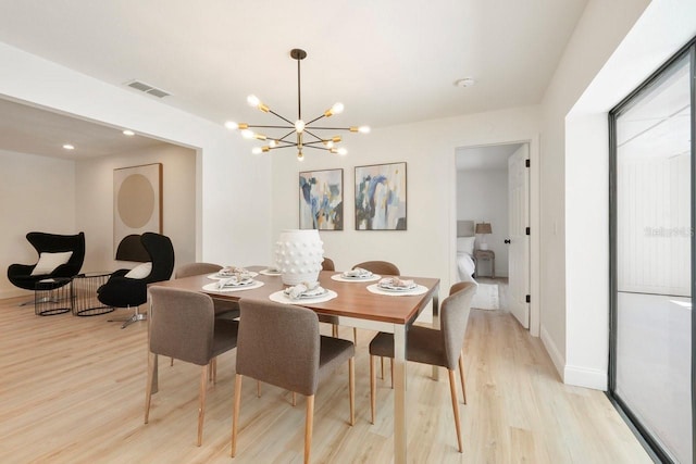 dining room featuring light wood-style flooring, visible vents, and baseboards