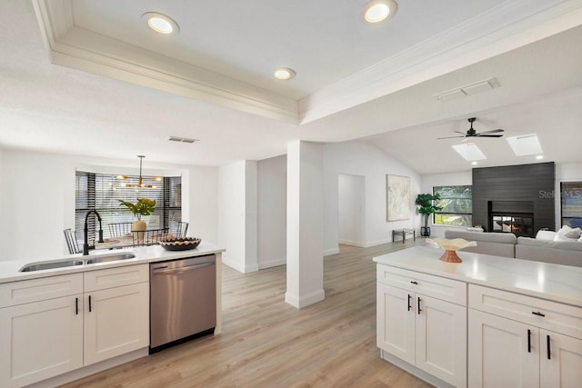 kitchen with visible vents, ornamental molding, open floor plan, a sink, and dishwasher