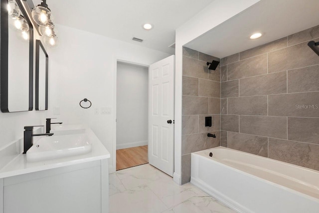 bathroom with recessed lighting, a sink, marble finish floor, shower / washtub combination, and double vanity