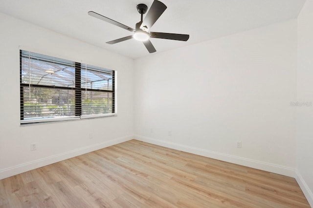 spare room featuring light wood-style floors, ceiling fan, and baseboards