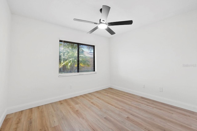 spare room with light wood-type flooring, ceiling fan, and baseboards