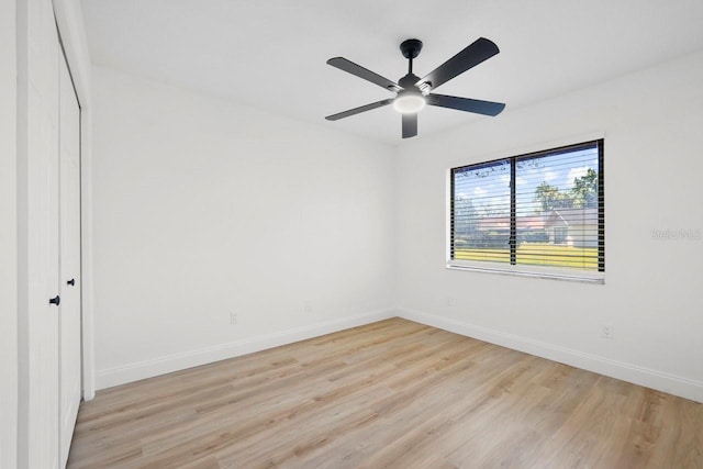 unfurnished room featuring light wood-type flooring, a ceiling fan, and baseboards