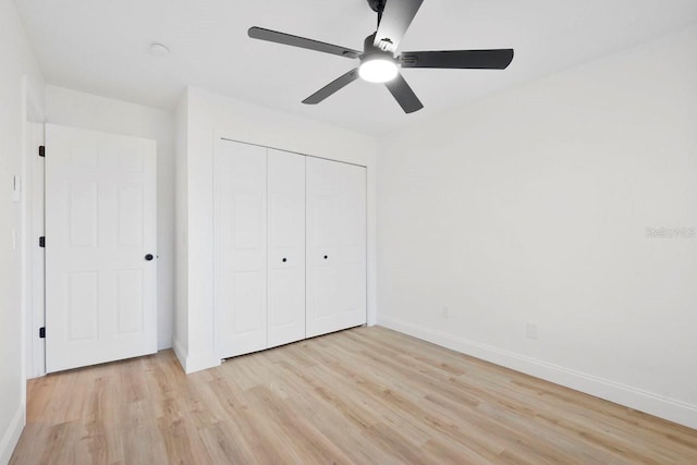 unfurnished bedroom with light wood-type flooring, a ceiling fan, baseboards, and a closet