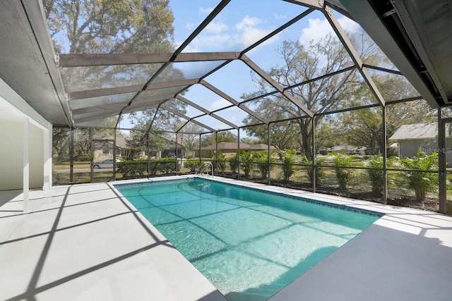 outdoor pool featuring glass enclosure and a patio area