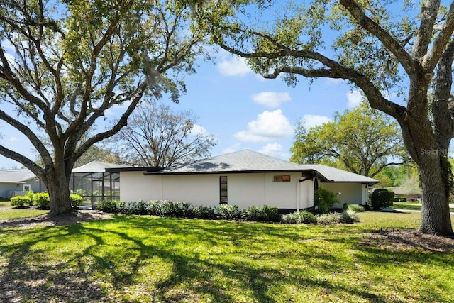 view of property exterior with a lanai and a lawn