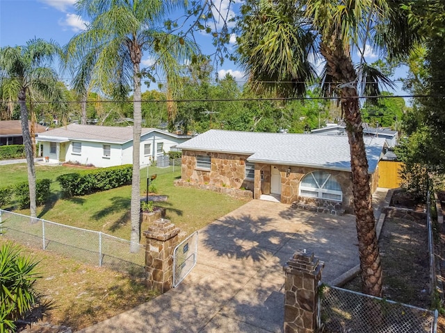 view of front of home featuring a fenced front yard, stone siding, concrete driveway, and a front yard