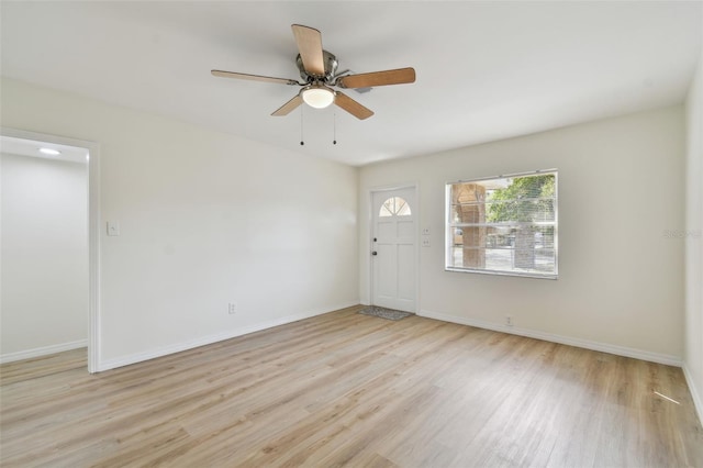 empty room with ceiling fan, baseboards, and wood finished floors