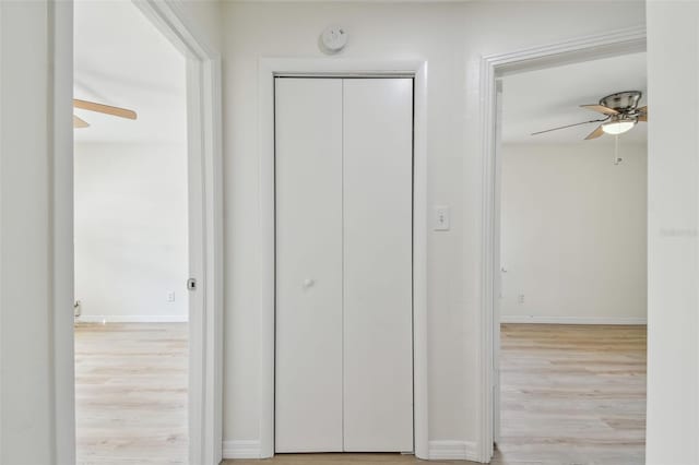 corridor with wood finished floors and baseboards