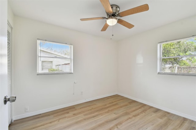 spare room with a ceiling fan, baseboards, and light wood-type flooring