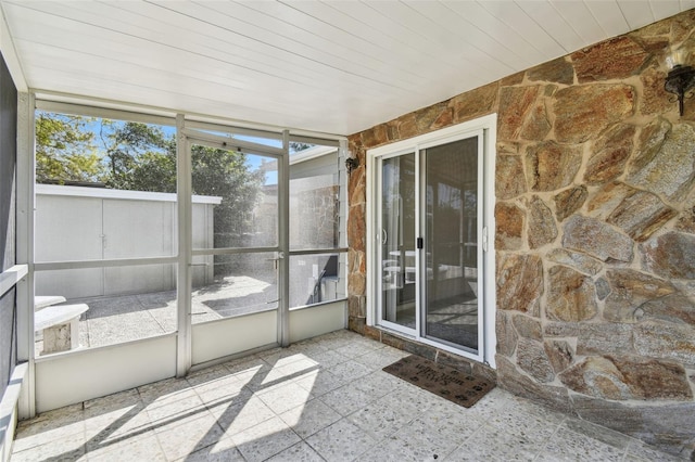 unfurnished sunroom with wood ceiling and a healthy amount of sunlight