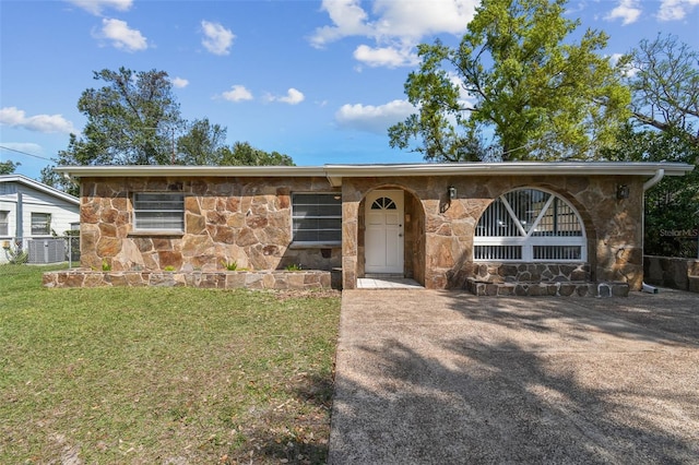 view of front of house with stone siding, central AC, and a front yard